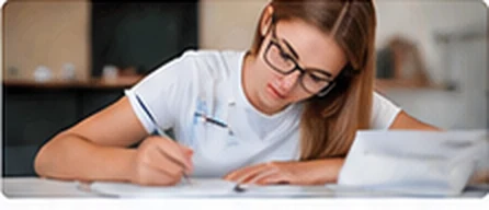 Estudiante con gafas escribiendo en un cuaderno